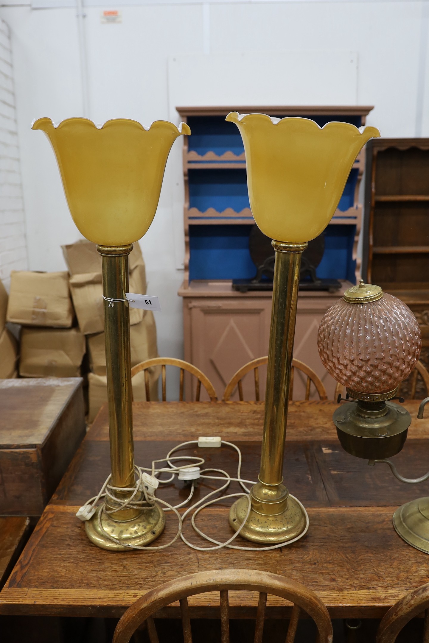 A pair of tall brass table lamps, height 65cm together with a brass two branch oil lamp with peach glass shades